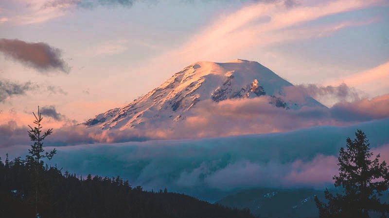 Clouds surround Mount Rainier at sunset in this photograph taken from U.S. Highway 12 near White Pass.